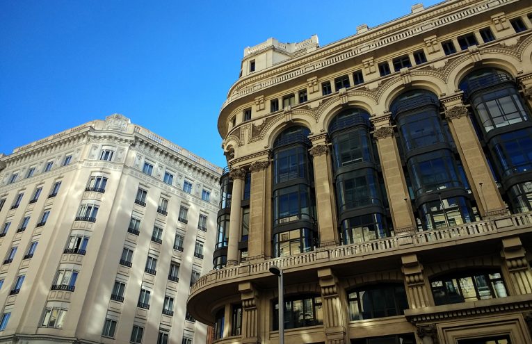 A low angle shot of buildings in Spain under a clear blue sky